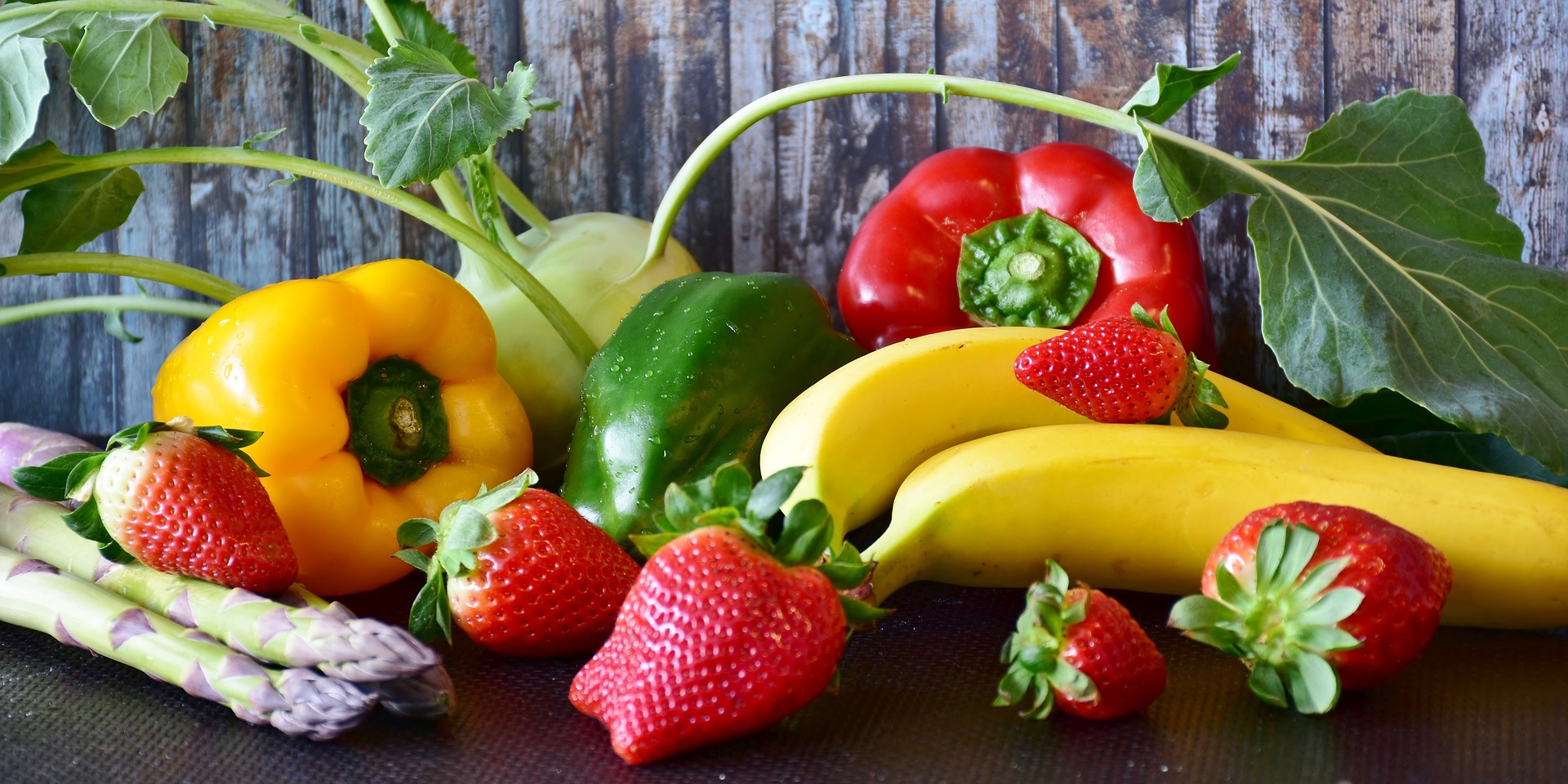 Collection of fruit and vegetables including strawberries, asparagus, bananas and peppers.