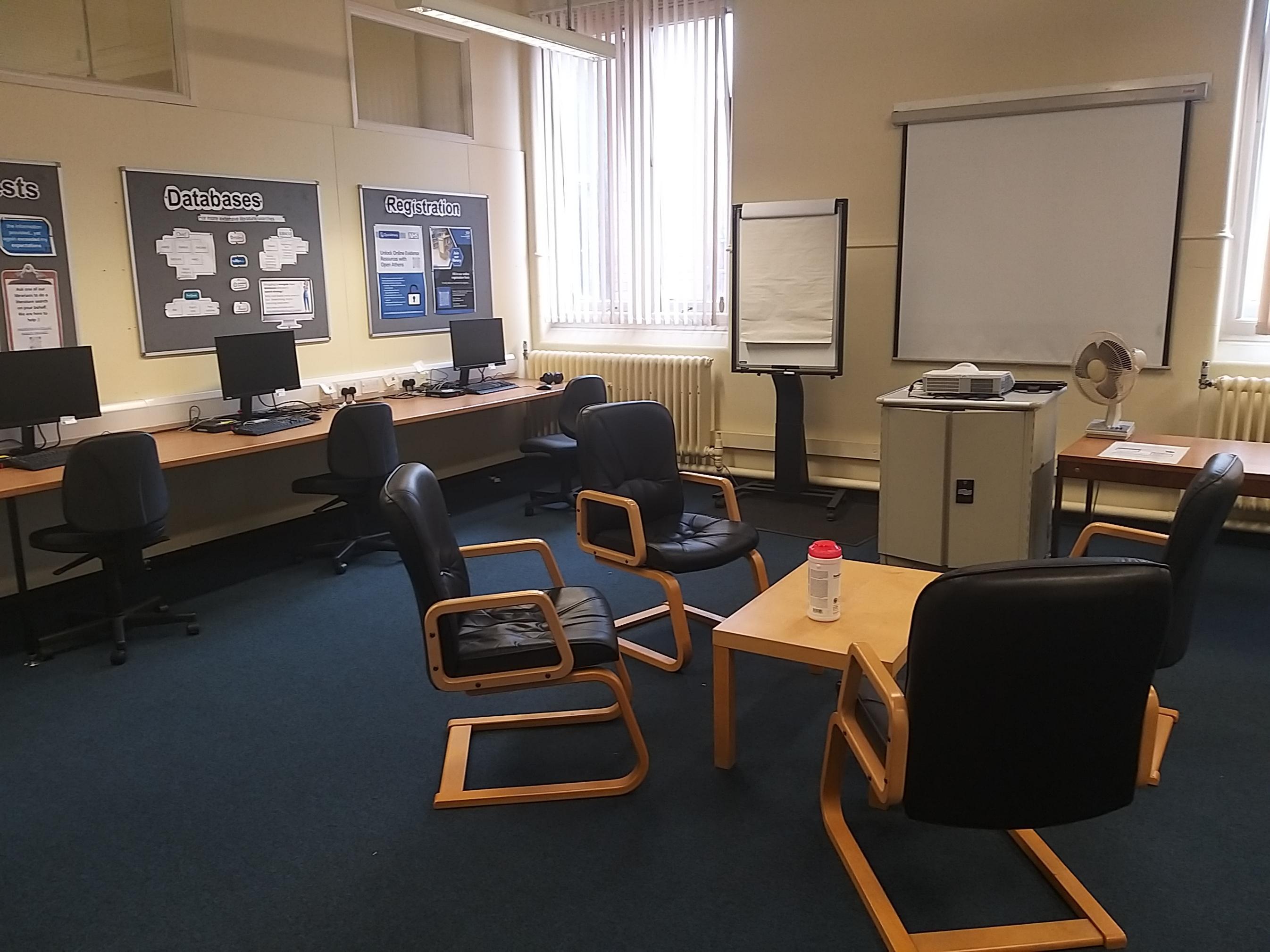 Photo of It Suite showing PCs facing the wall, a projector floor unit and flipchart