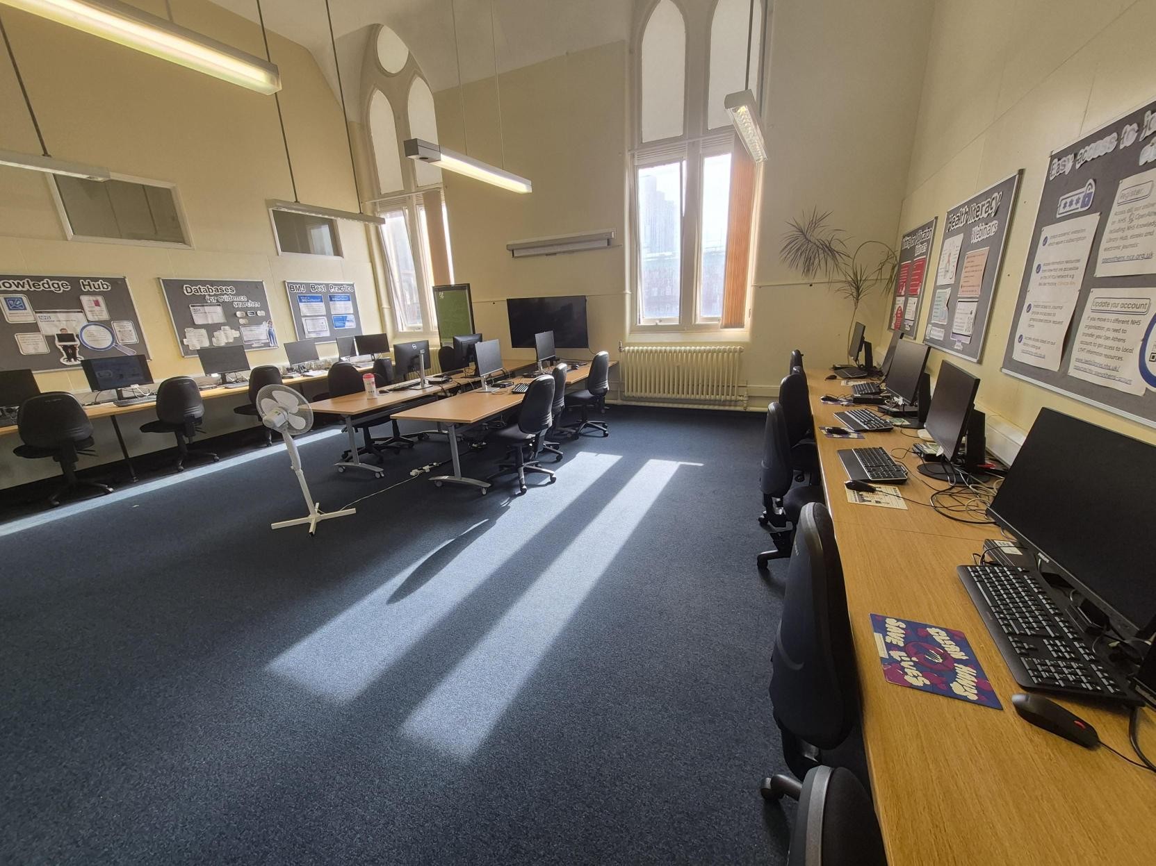 Computers against outer walls and computer table in the centre