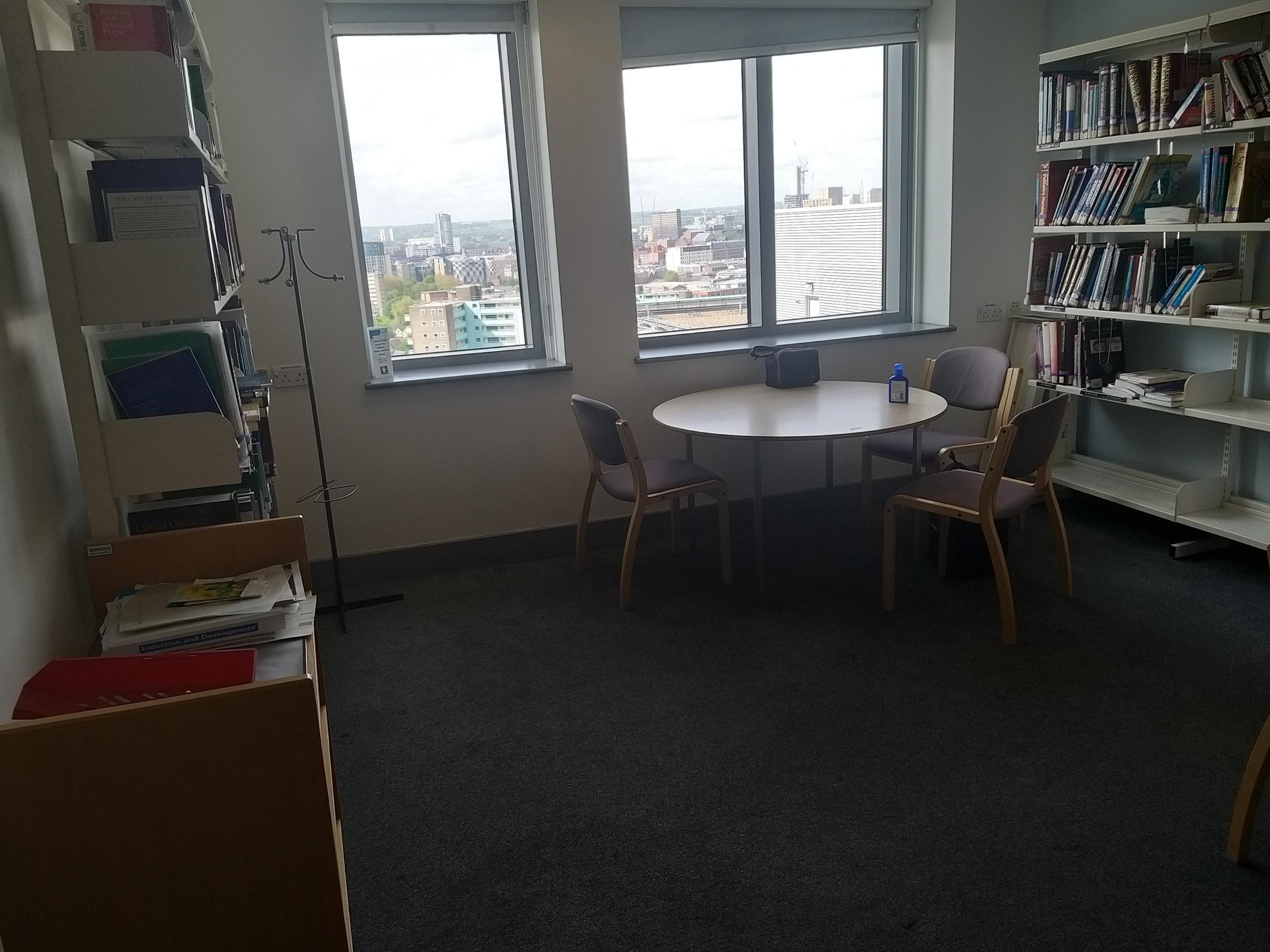 Photo of Bexley study space- showing a round study table and shelves of oncology books